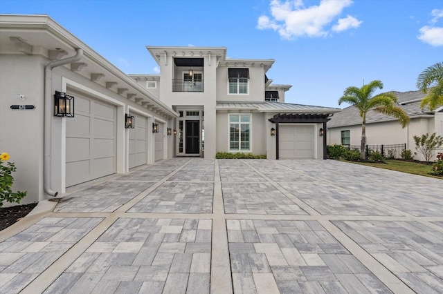 676 Regatta Way, Bradenton, FL 34208 - view of front of house with a standing seam roof, stucco siding, decorative driveway, a garage, and a metal roof