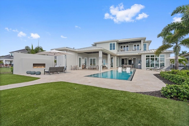 676 Regatta Way, Bradenton, FL 34208 - rear view of property with an outdoor living space with a fireplace, a ceiling fan, a patio, and stucco siding