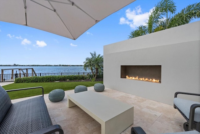 676 Regatta Way, Bradenton, FL 34208 - view of patio / terrace with a water view and a warm lit fireplace