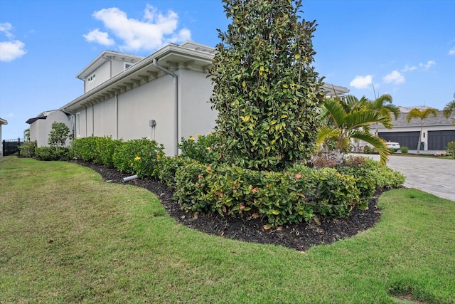676 Regatta Way, Bradenton, FL 34208 - view of side of home featuring a lawn, driveway, and stucco siding