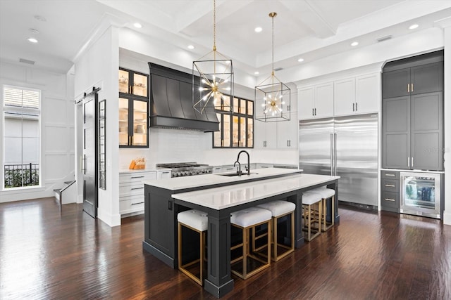 676 Regatta Way, Bradenton, FL 34208 - kitchen featuring stainless steel built in fridge, custom range hood, a center island with sink, light countertops, and recessed lighting