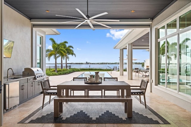 676 Regatta Way, Bradenton, FL 34208 - view of patio / terrace featuring exterior kitchen, outdoor dining space, a water view, and a ceiling fan