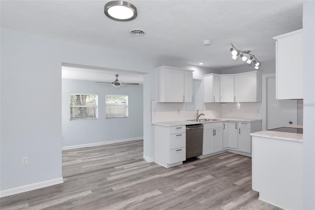 4505 18th Ave W, Bradenton, FL 34209 - kitchen with stainless steel dishwasher, light wood-style flooring, white cabinetry, and light countertops