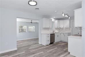 4505 18th Ave W, Bradenton, FL 34209 - kitchen featuring dishwasher, light countertops, wood finished floors, and white cabinetry