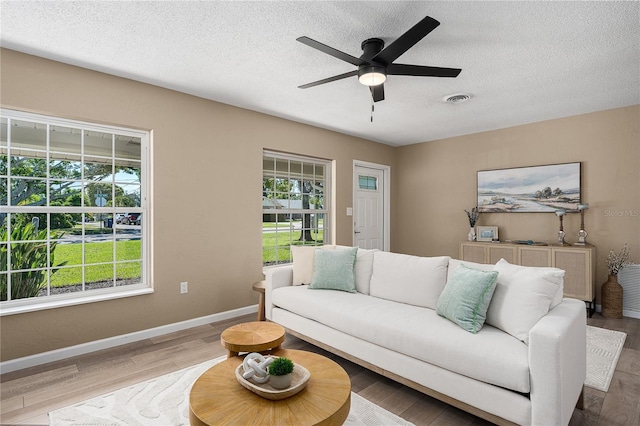 616 59th St NW, Bradenton, FL 34209 - living room featuring a textured ceiling, a ceiling fan, and wood finished floors