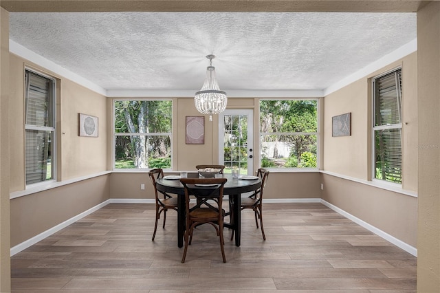 616 59th St NW, Bradenton, FL 34209 - dining space featuring wood finished floors, a chandelier, and a textured ceiling