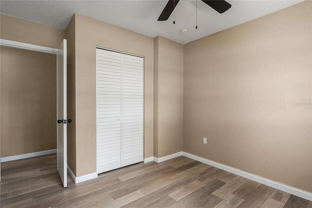 616 59th St NW, Bradenton, FL 34209 - unfurnished bedroom featuring wood finished floors, a closet, and a ceiling fan