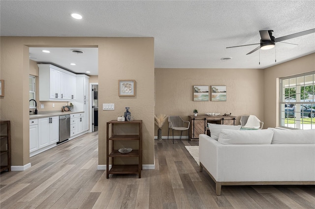 616 59th St NW, Bradenton, FL 34209 - living area featuring ceiling fan, light wood finished floors, a textured ceiling, and recessed lighting