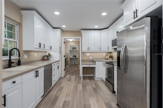 616 59th St NW, Bradenton, FL 34209 - kitchen with appliances with stainless steel finishes, light wood-style flooring, white cabinets, light countertops, and recessed lighting