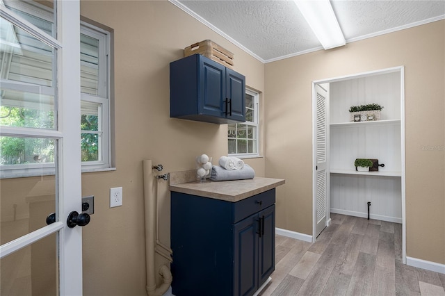 616 59th St NW, Bradenton, FL 34209 - laundry area with light wood finished floors, a textured ceiling, and ornamental molding