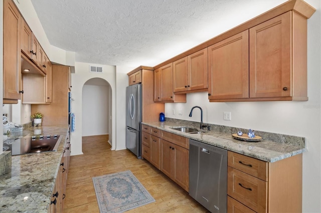 2425 Gulf Of Mexico Dr Unit 10F, Longboat Key, FL 34228 - kitchen featuring stainless steel appliances, arched walkways, a textured ceiling, and light stone countertops
