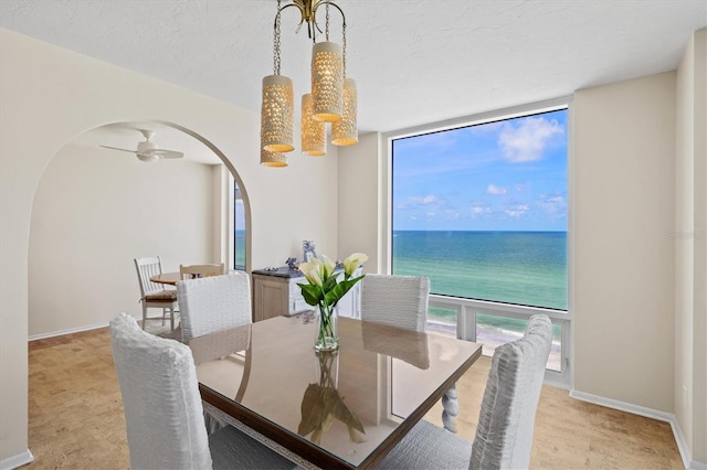 2425 Gulf Of Mexico Dr Unit 10F, Longboat Key, FL 34228 - dining room featuring arched walkways, light carpet, and a water view
