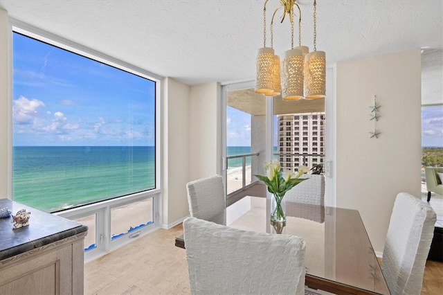2425 Gulf Of Mexico Dr Unit 10F, Longboat Key, FL 34228 - dining area featuring a textured ceiling, a water view, and light wood-style floors