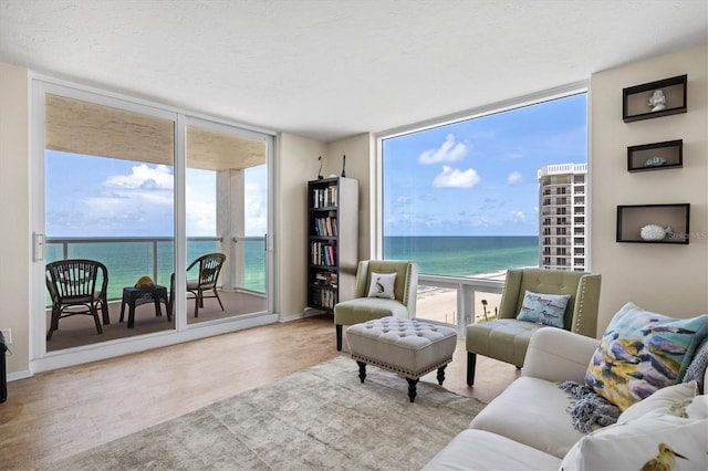 2425 Gulf Of Mexico Dr Unit 10F, Longboat Key, FL 34228 - living area featuring a wall of windows, a water view, healthy amount of natural light, and a textured ceiling