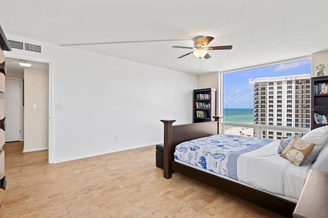 2425 Gulf Of Mexico Dr Unit 10F, Longboat Key, FL 34228 - bedroom with a ceiling fan, wood finished floors, expansive windows, and a water view