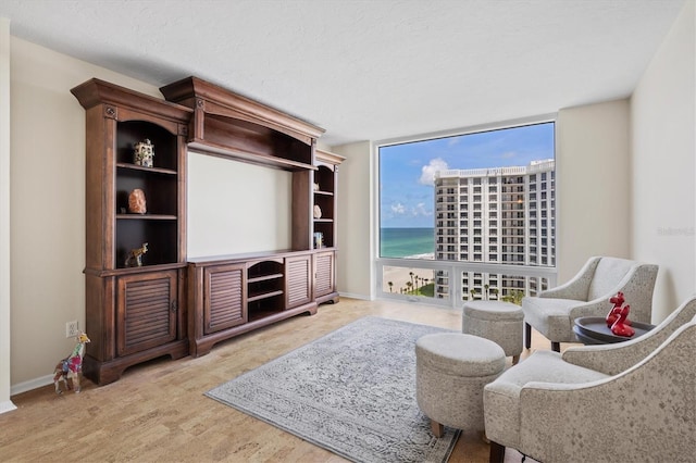 2425 Gulf Of Mexico Dr Unit 10F, Longboat Key, FL 34228 - sitting room featuring floor to ceiling windows, wood finished floors, and a water view