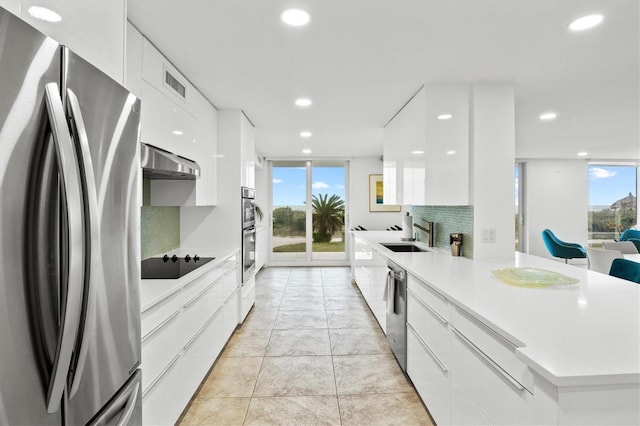 2425 Gulf Of Mexico Dr Unit 10F, Longboat Key, FL 34228 - kitchen featuring stainless steel appliances, modern cabinets, wall chimney range hood, white cabinetry, and recessed lighting