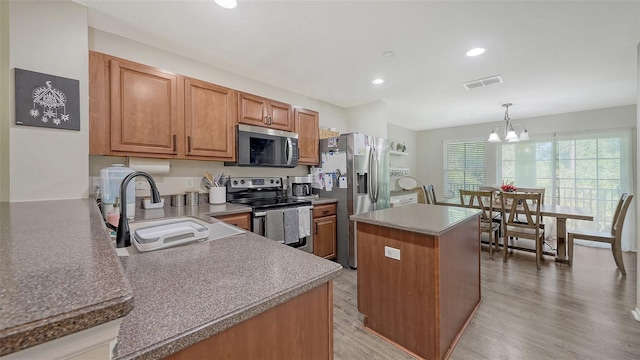 8907 White Sage Loop, Lakewood Ranch, FL 34202 - kitchen featuring appliances with stainless steel finishes, a center island, brown cabinetry, a chandelier, and recessed lighting