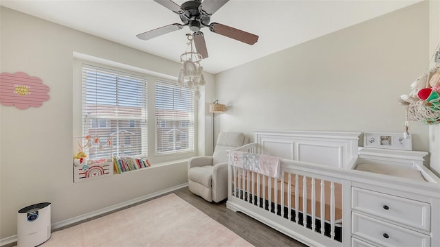 8907 White Sage Loop, Lakewood Ranch, FL 34202 - bedroom featuring wood finished floors, a nursery area, and a ceiling fan