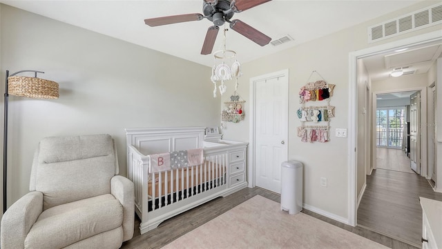 8907 White Sage Loop, Lakewood Ranch, FL 34202 - bedroom with wood finished floors, a nursery area, and ceiling fan