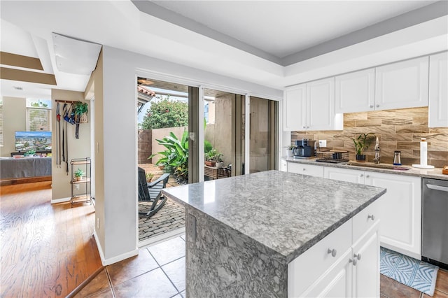 200 Cocoanut Ave Unit 1, Sarasota, FL 34236 - kitchen with stainless steel dishwasher, backsplash, light stone countertops, and white cabinets