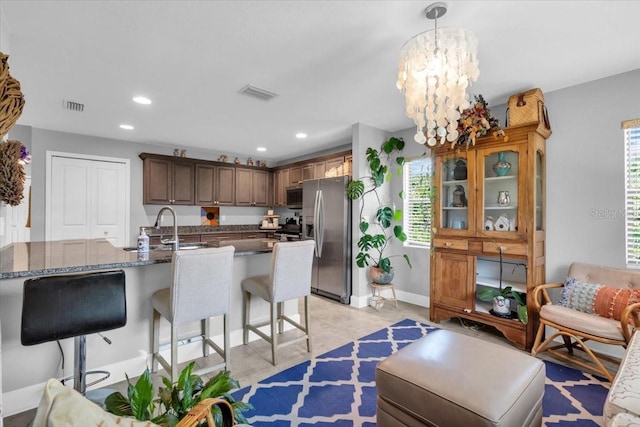 529 Sunset Rd N, Rotonda West, FL 33947 - kitchen featuring appliances with stainless steel finishes, healthy amount of natural light, a kitchen breakfast bar, recessed lighting, and dark stone countertops