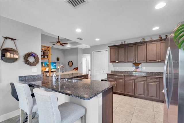 529 Sunset Rd N, Rotonda West, FL 33947 - kitchen featuring freestanding refrigerator, a breakfast bar, recessed lighting, dark stone counters, and ceiling fan
