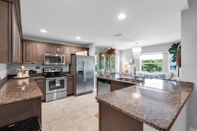 529 Sunset Rd N, Rotonda West, FL 33947 - kitchen featuring stainless steel appliances, dark stone counters, a chandelier, light tile patterned floors, and recessed lighting