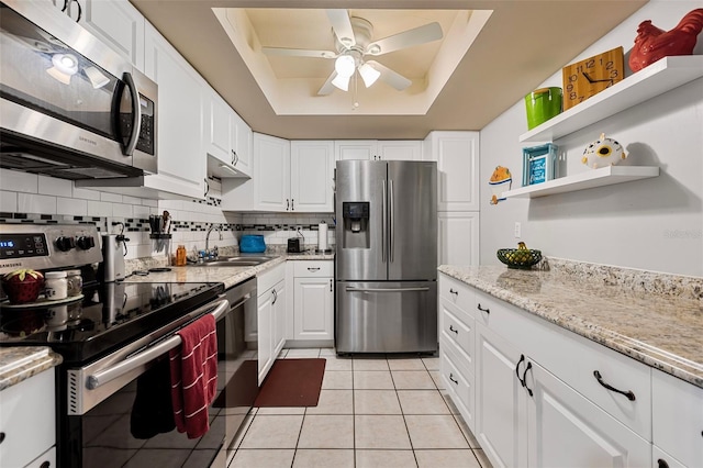 618 Bird Bay Dr S Unit 113, Venice, FL 34285 - kitchen featuring stainless steel appliances, a raised ceiling, decorative backsplash, ceiling fan, and white cabinetry