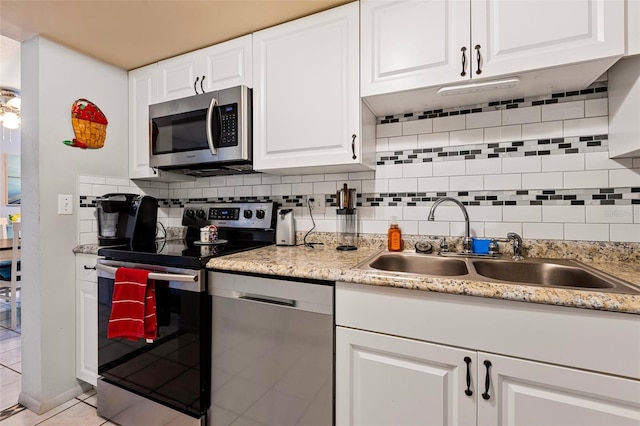 618 Bird Bay Dr S Unit 113, Venice, FL 34285 - kitchen featuring stainless steel appliances, decorative backsplash, white cabinets, and light tile patterned floors