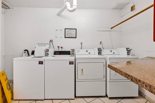 618 Bird Bay Dr S Unit 113, Venice, FL 34285 - shared laundry room featuring independent washer and dryer and light tile patterned floors