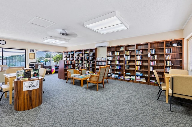 618 Bird Bay Dr S Unit 113, Venice, FL 34285 - living area with a wall unit AC, carpet, a textured ceiling, and wall of books
