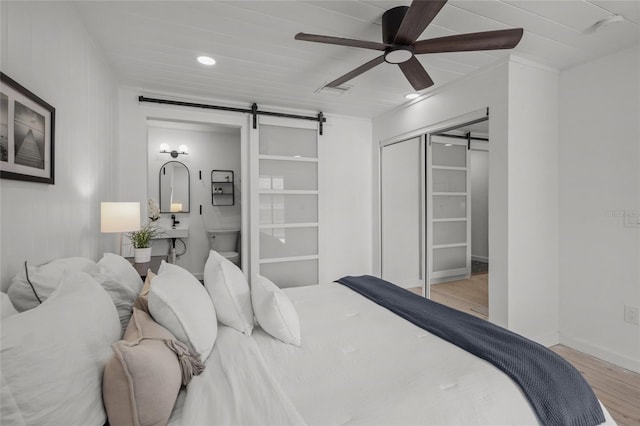 3310 W 9th Ave, Bradenton, FL 34205 - bedroom with a barn door, wood finished floors, a closet, ceiling fan, and recessed lighting