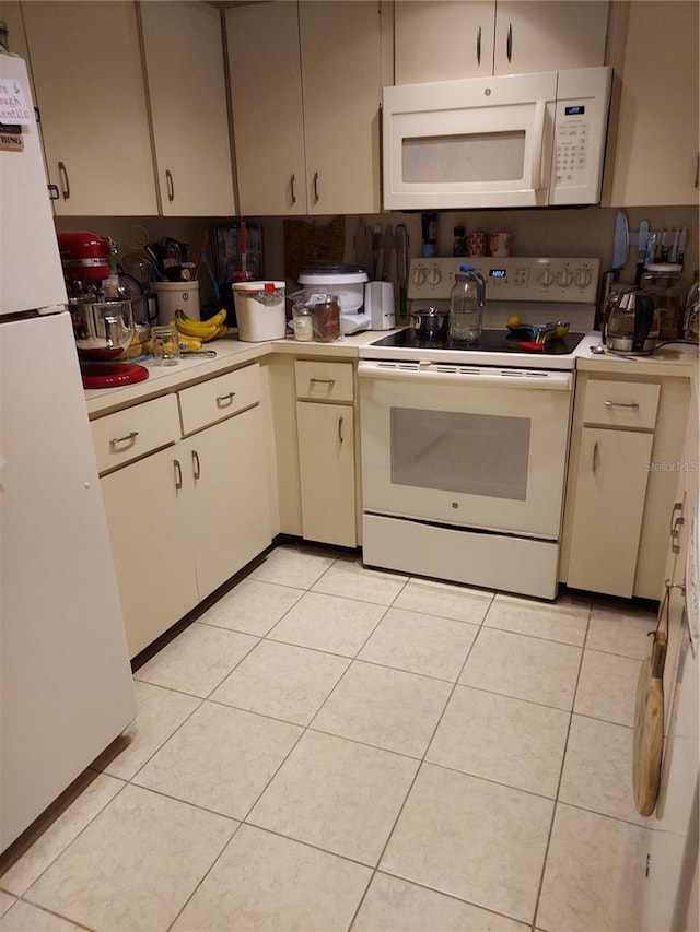 6132 29th Ave W, Bradenton, FL 34209 - kitchen featuring white appliances, light countertops, light tile patterned floors, and cream cabinetry