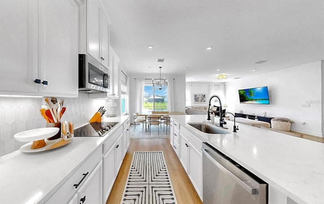 6120 115th Ave E, Parrish, FL 34219 - kitchen with appliances with stainless steel finishes, open floor plan, light wood-type flooring, white cabinetry, and recessed lighting