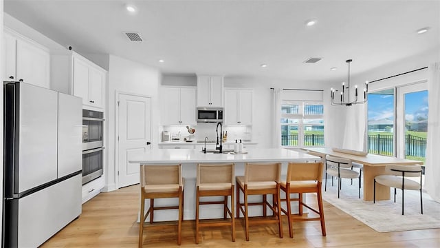 6120 115th Ave E, Parrish, FL 34219 - kitchen featuring appliances with stainless steel finishes, light wood finished floors, light countertops, white cabinetry, and recessed lighting
