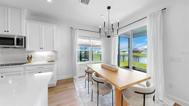 6120 115th Ave E, Parrish, FL 34219 - dining area with light wood finished floors, a chandelier, a water view, and recessed lighting