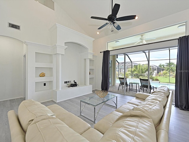 5184 51st Ln W, Bradenton, FL 34210 - living room with a ceiling fan, high vaulted ceiling, arched walkways, built in shelves, and a sunroom