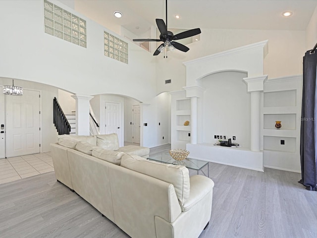 5184 51st Ln W, Bradenton, FL 34210 - living area with arched walkways, a ceiling fan, decorative columns, wood finished floors, and stairs