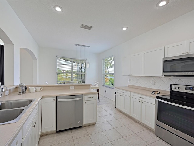 5184 51st Ln W, Bradenton, FL 34210 - kitchen featuring appliances with stainless steel finishes, white cabinetry, light countertops, decorative backsplash, and recessed lighting