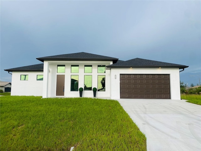 9150 Key W St, Port Charlotte, FL 33981 - prairie-style house with stucco siding, an attached garage, concrete driveway, and a front lawn