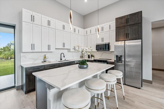 9150 Key W St, Port Charlotte, FL 33981 - kitchen with stainless steel appliances, light stone countertops, light wood-style floors, a kitchen island, and hanging light fixtures