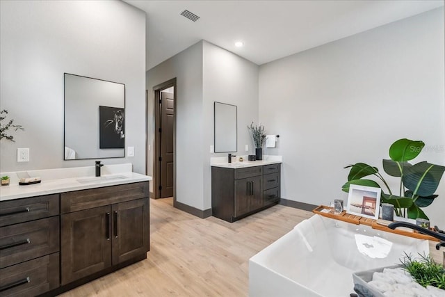 9150 Key W St, Port Charlotte, FL 33981 - full bath with wood finished floors, two vanities, a freestanding tub, and recessed lighting