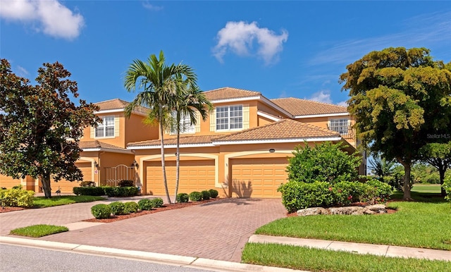 318 Winding Brook Ln Unit 104, Bradenton, FL 34212 - view of property with decorative driveway, stucco siding, a tiled roof, and a garage