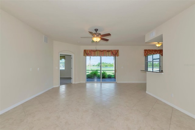 318 Winding Brook Ln Unit 104, Bradenton, FL 34212 - spare room featuring ceiling fan, plenty of natural light, arched walkways, and light tile patterned floors