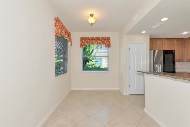 318 Winding Brook Ln Unit 104, Bradenton, FL 34212 - kitchen featuring stainless steel refrigerator with ice dispenser, light tile patterned flooring, recessed lighting, stone countertops, and decorative backsplash
