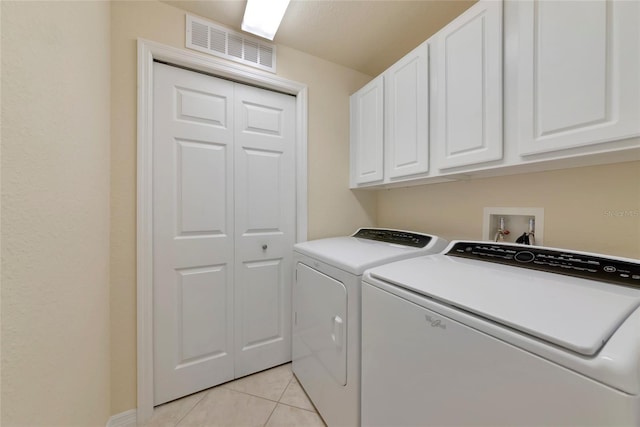318 Winding Brook Ln Unit 104, Bradenton, FL 34212 - washroom with washing machine and clothes dryer, cabinet space, and light tile patterned floors