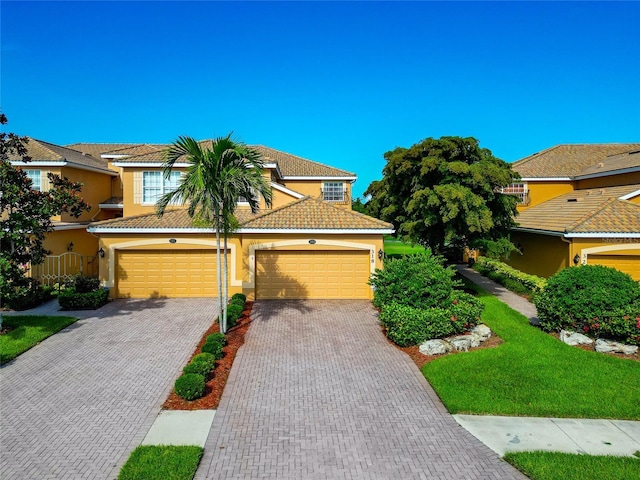 318 Winding Brook Ln Unit 104, Bradenton, FL 34212 - view of front of property with stucco siding, driveway, a tiled roof, and an attached garage