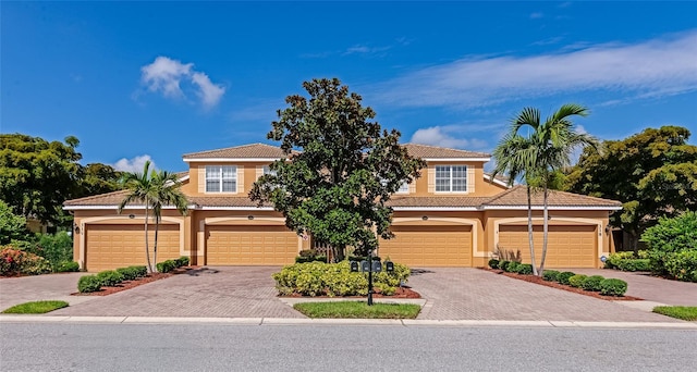318 Winding Brook Ln Unit 104, Bradenton, FL 34212 - view of front of house featuring stucco siding, driveway, a tiled roof, and an attached garage