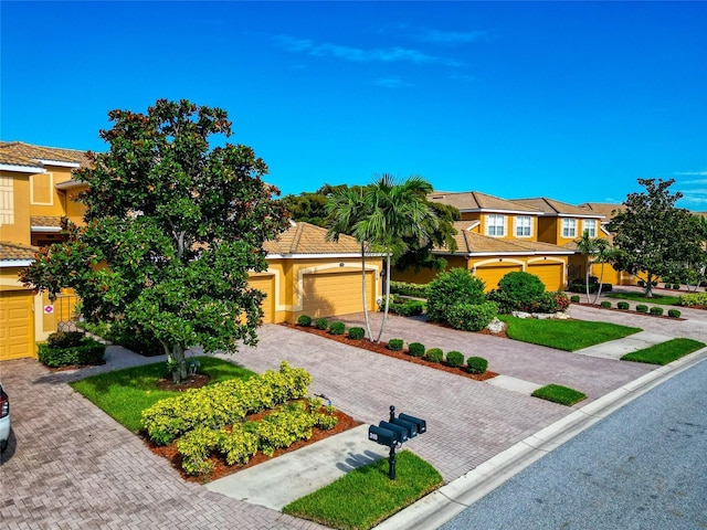 318 Winding Brook Ln Unit 104, Bradenton, FL 34212 - view of front of house with decorative driveway, stucco siding, a residential view, and a garage
